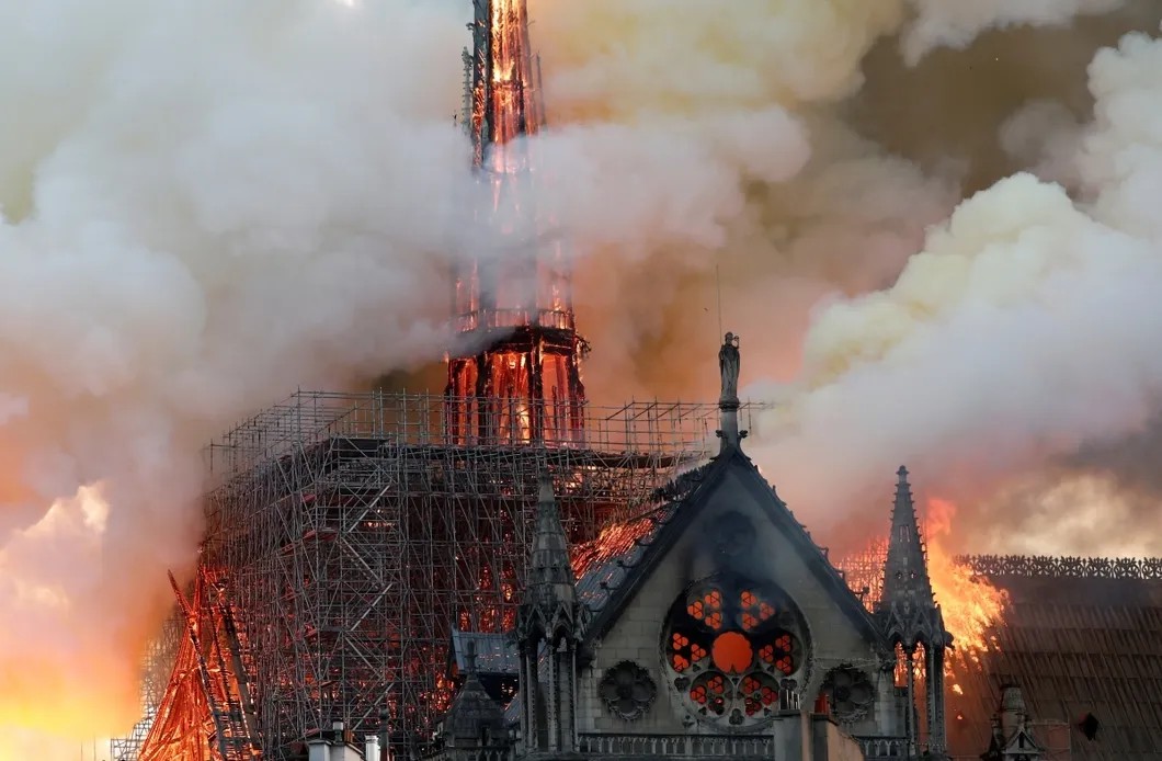 Пламя очень быстро охватило крышу и шпиль собора. Через несколько часов несущие перекрытия — тоже деревянные — не выдержат. Фото: EPA