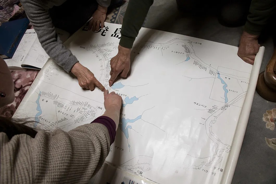 Такеучи-сан показывает на японской карте остров Зеленый, где стоял его дом. Фото: Анна Артемьева / «Новая»
