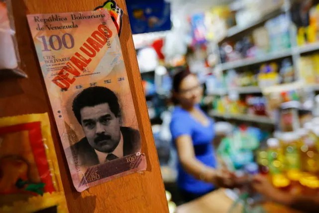 Обесцененные 100 венесуэльских боливаров с изображением президента Николаса Мадуро в магазине Каракаса. Фото: Reuters