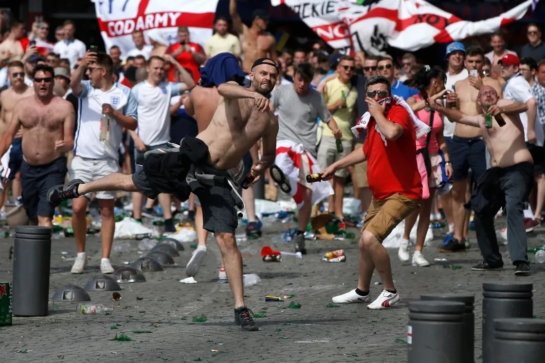 Английские фанаты бросают бутылки в полицию около пивного бара в районе Старого порта. Фото: EPA