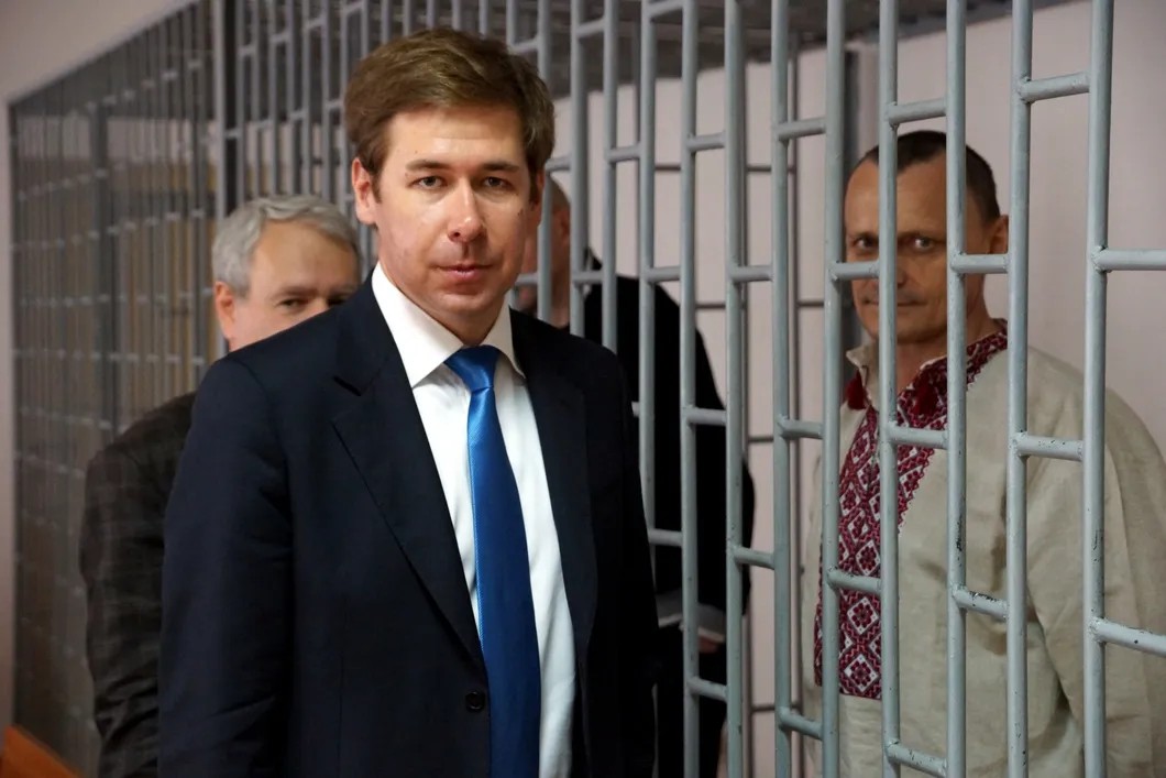 Илья Новиков в зале чеченского суда. В клетке — его подзащитный Карпюк. Фото: Антон Наумлюк, специально для «Новой газеты»