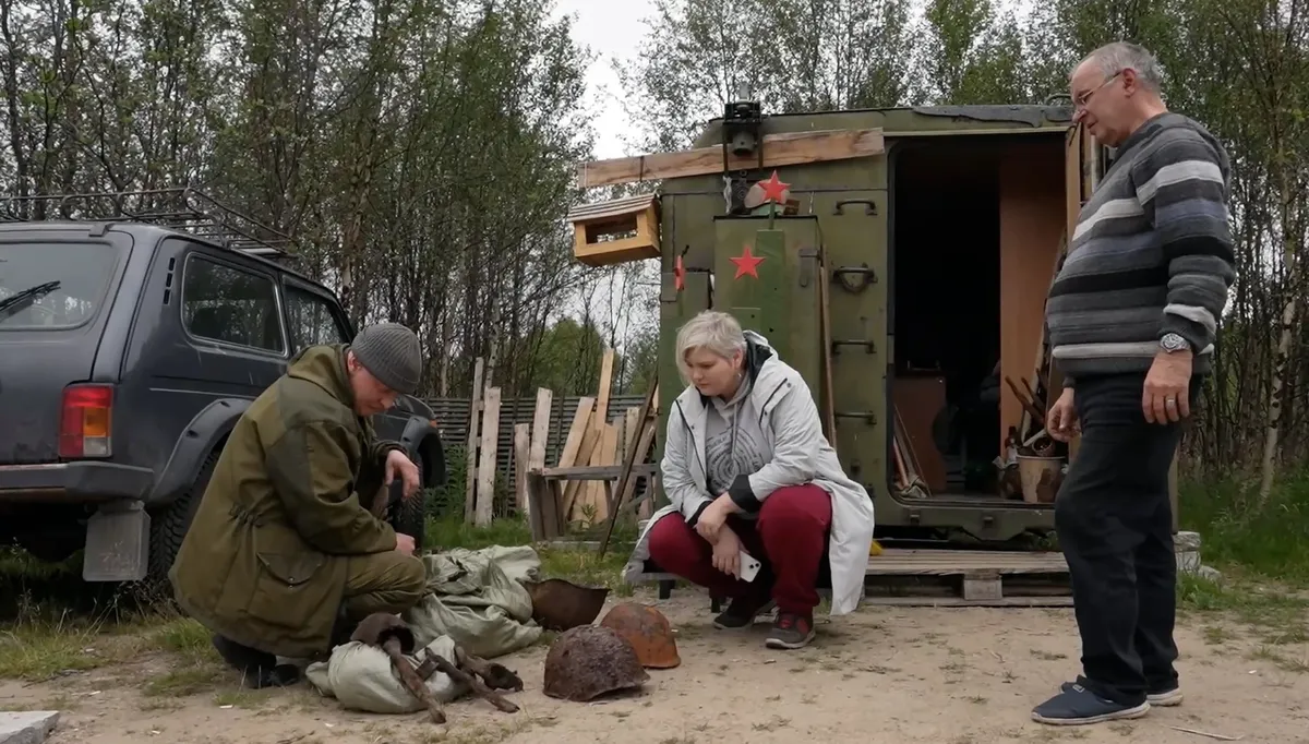 Поисковики Алексей Смолев и Константин Добровольский с журналистом «Новой» Татьяной Брицкой осматривают останки найденных солдат. Кадр из фильма «Иван-чай» документального проекта «Командировка»