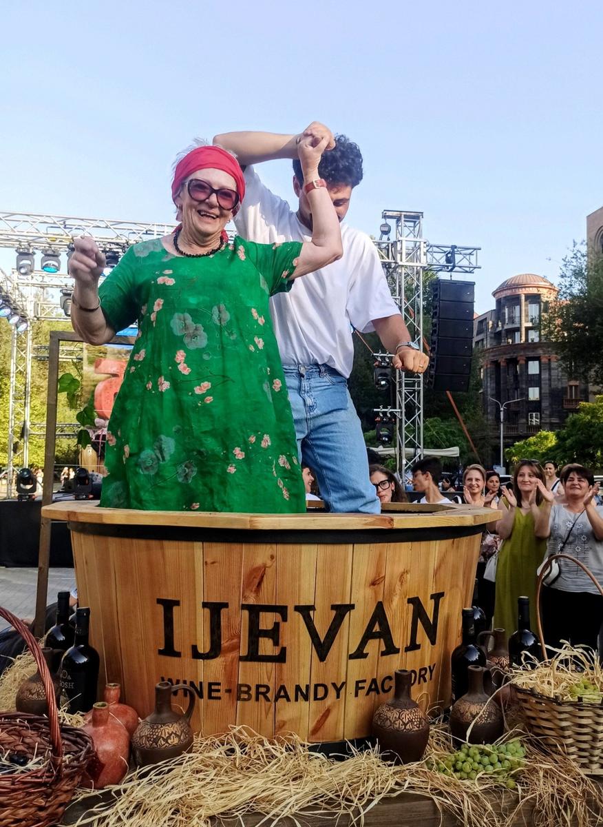 Туристка из Новой Зеландии давит ногами винные ягоды на празднике освящения винограда. Ереван, EnoFest, 17.08.2025. Фото: Евгения Енгибарян