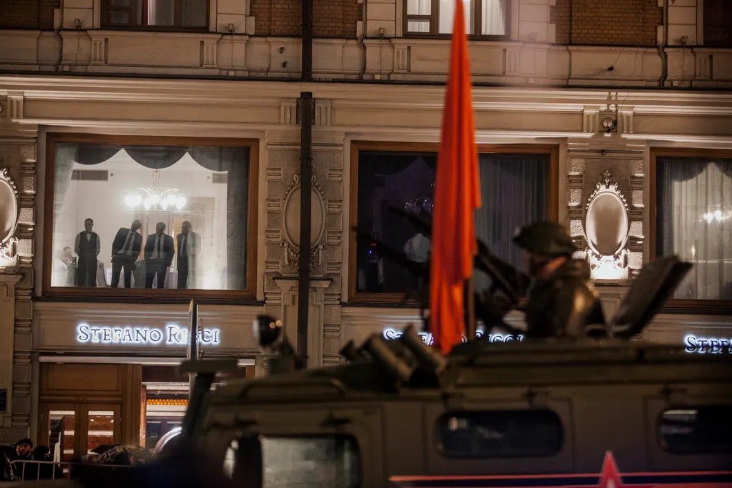 Посетители ресторана смотрят в окно на военные машины. Фото: Влад Докшин / «Новая газета»