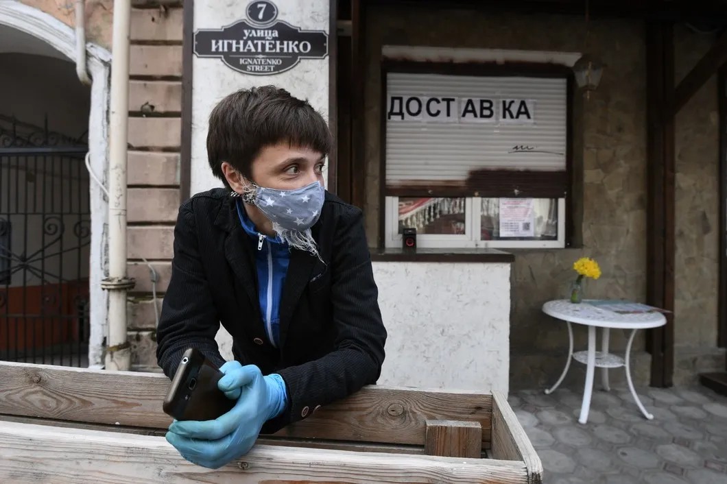 Девушка в маске на одной из улиц в Ялте. Фото: Константин Михальчевский / РИА Новости