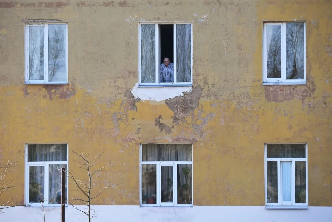 Постоялец в окне здания дома-интерната для престарелых в Вязьме. Фото: РИА Новости