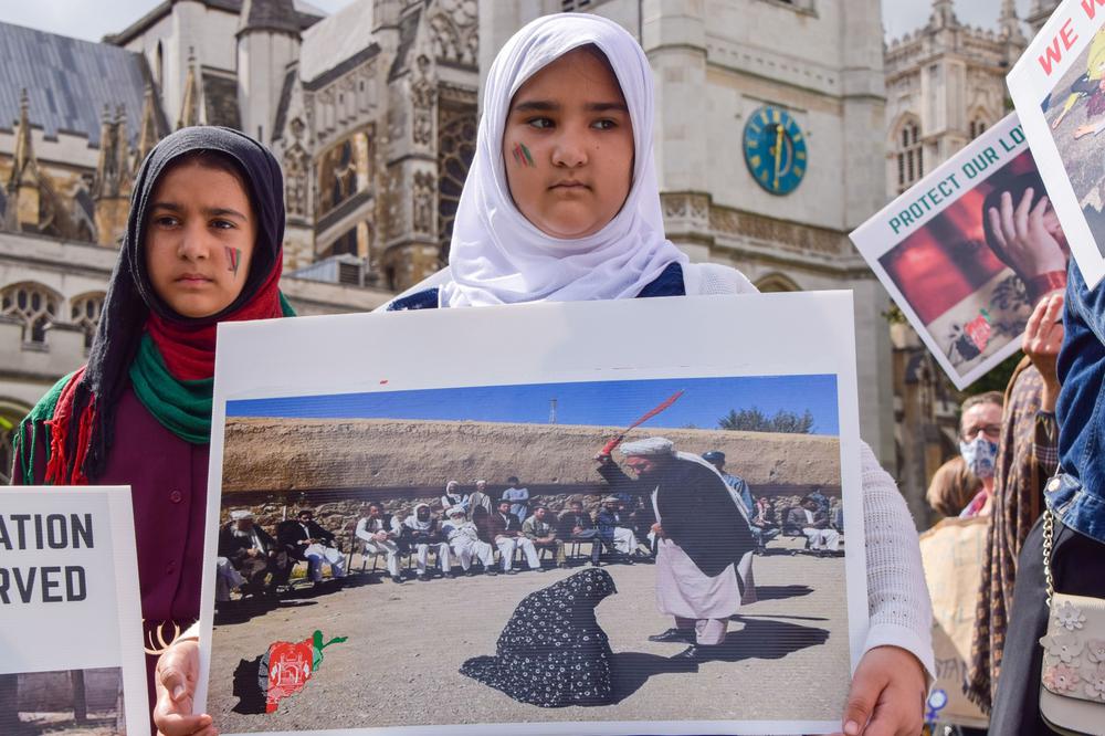Девушка держит фото публичного избиения женщины во время акции протеста против действий Талибана, Лондон. Фото: Vuk Valcic / SOPA Images / LightRocket via Getty Images