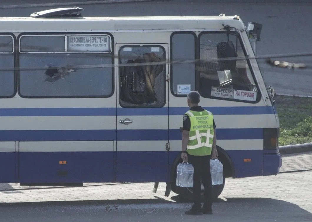Полицейский передает воду заложникам в автобусе. Фото: ЕРА