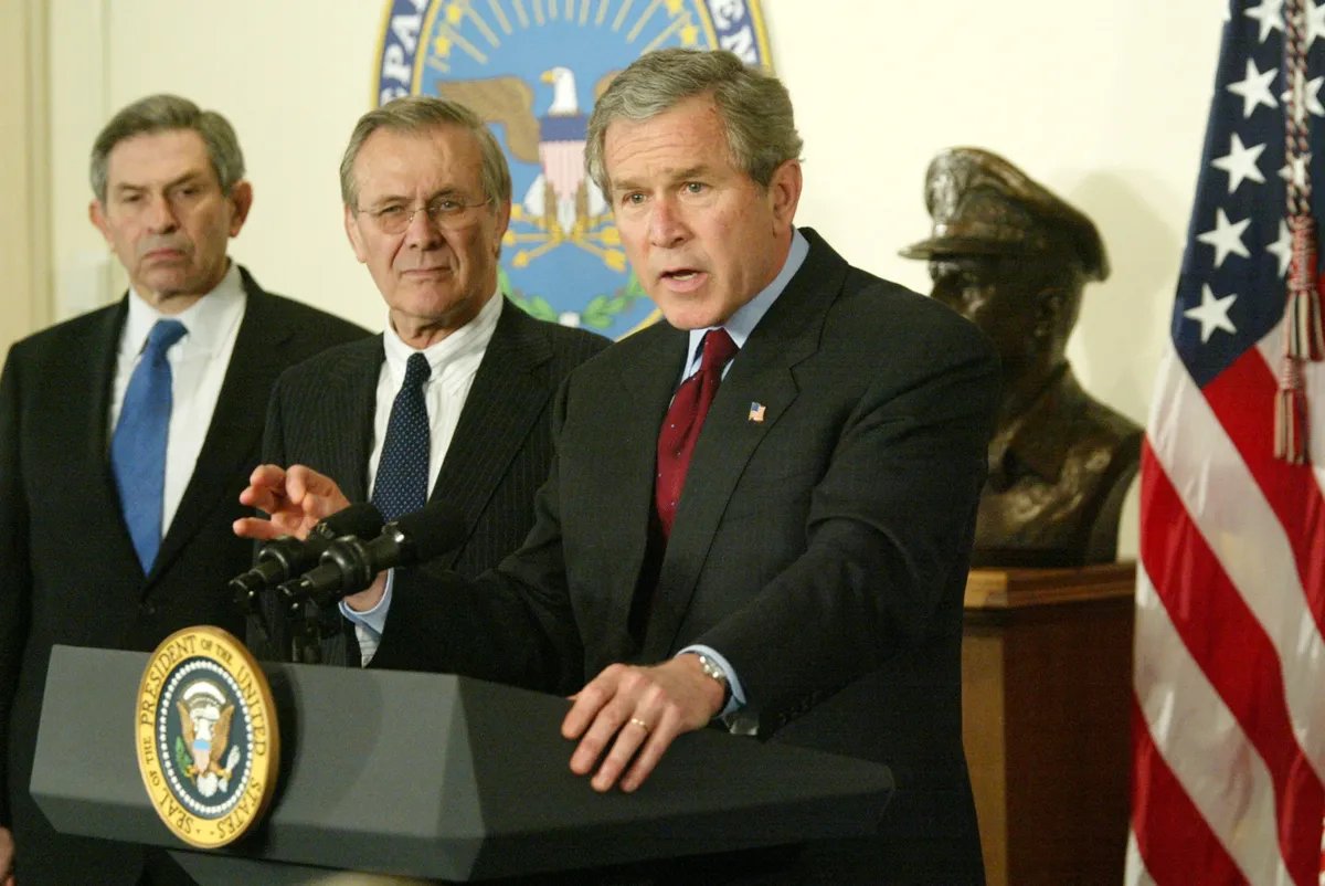 Дональд Рамсфелд (в центре) и Джордж Буш-младший. Фото: CNP / ABACA