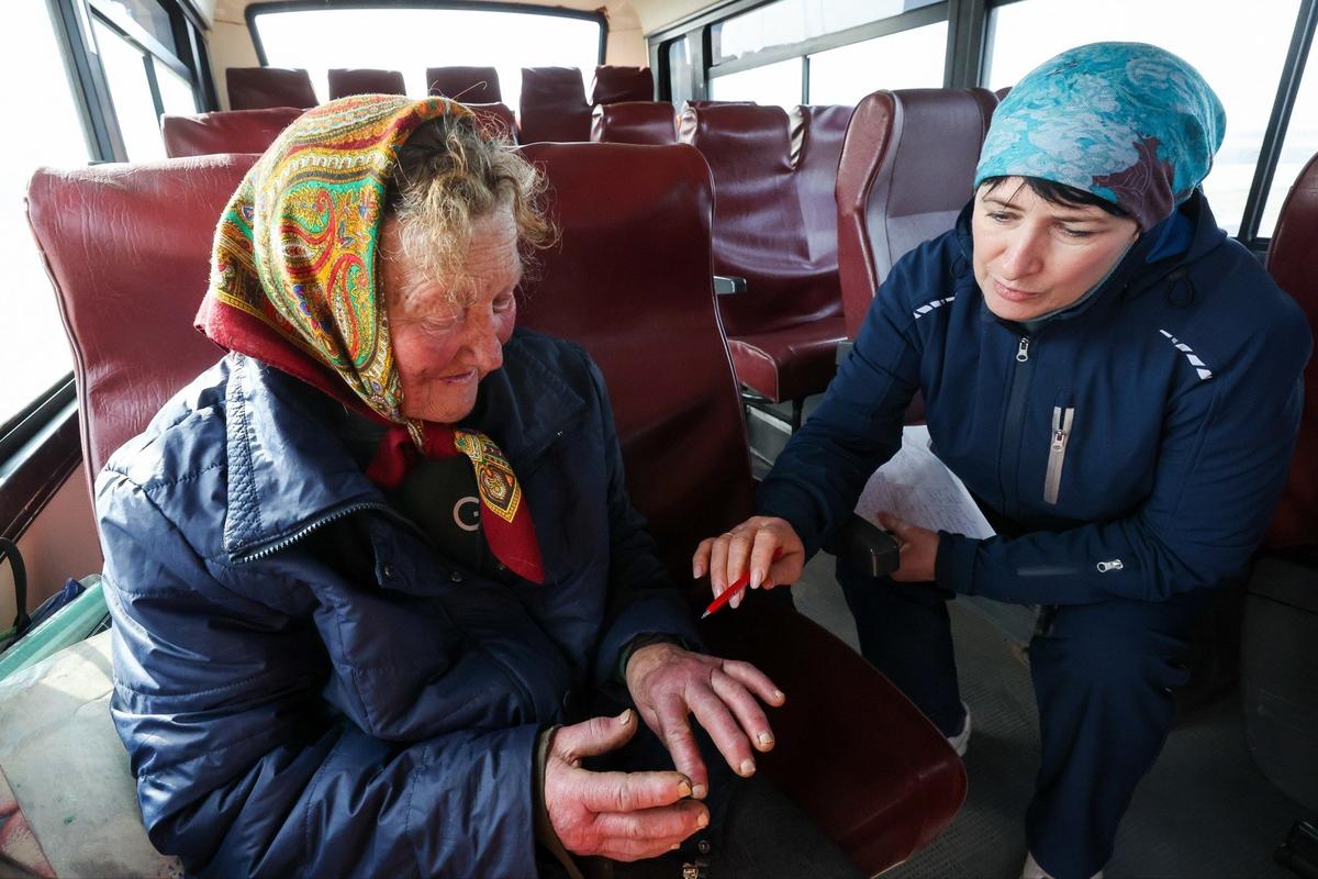 Март 2025 года. Женщина из Суджи и сотрудница Центра медицины катастроф во время эвакуации. Фото: Максим Григорьев / ТАСС