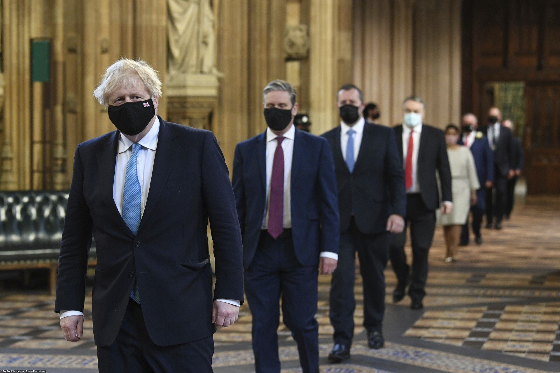 Премьер-министр Великобритании Борис Джонсон и лидер Лейбористской партии Кейр Стармер (второй слева) проходят через центральный вестибюль Палаты лордов перед началом речи королевы. Фото: EastNews