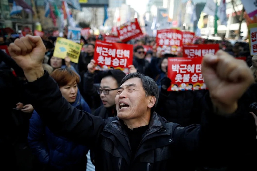 Протестующие узнали о решении Конституционного суда Кореи утвердить импичмент. Фото: Reuters