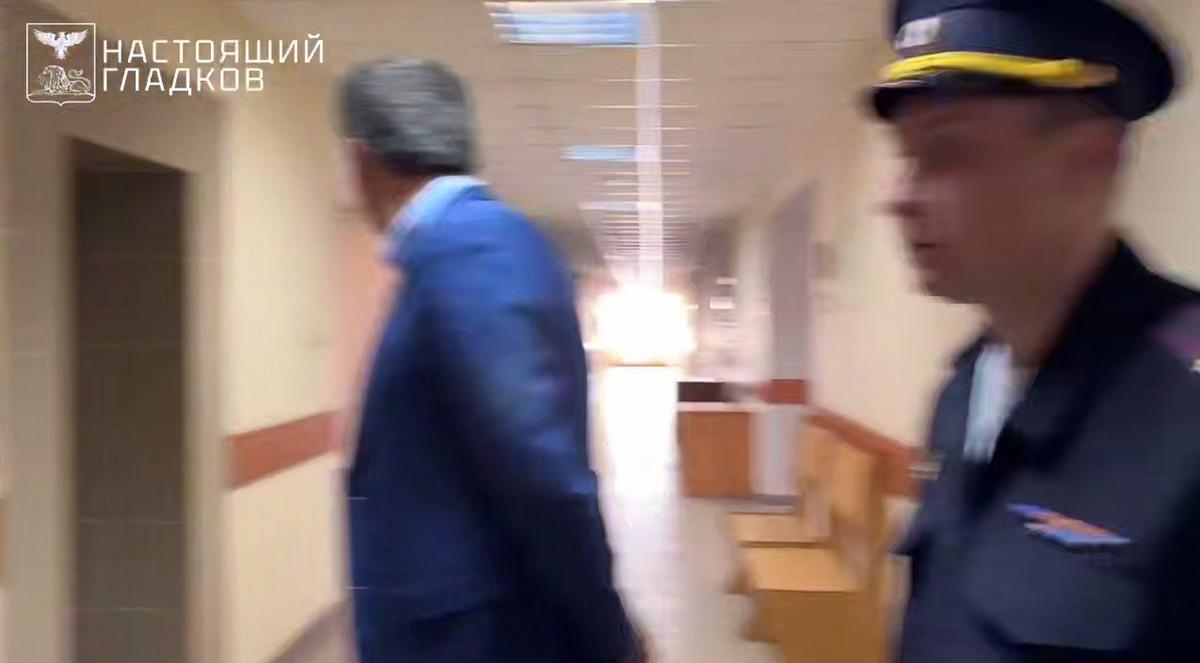 Кадр с моментом прилета дрона по зданию суда, Гладков, представитель суда и полицейский оборачиваются на звук взрыва