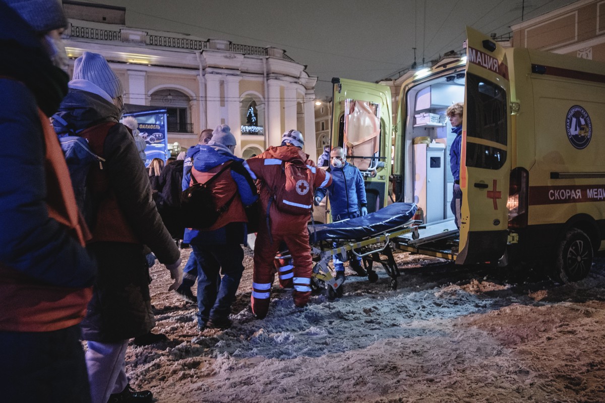 Волонтеры помогают врачам реанимационной бригады донести мужчину до машины скорой. Фото: Артем Лешко, специально для «Новой газеты»