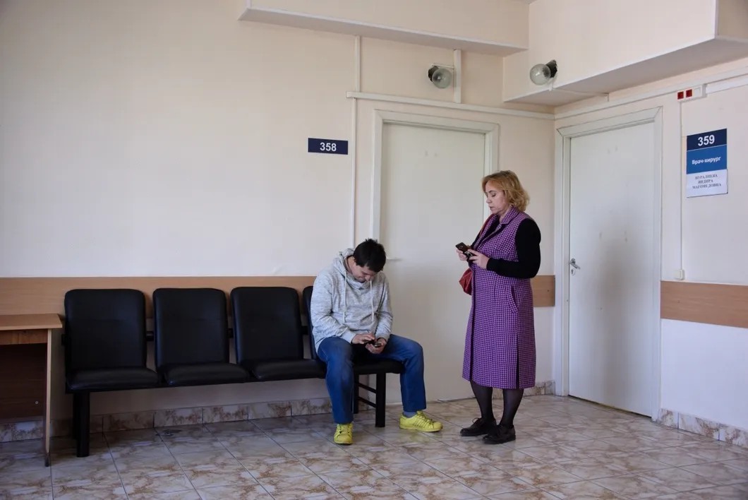 Паша с мамой в поликлинике у кабинета хирурга. Фото: Виктория Одиссонова / «Новая газета»