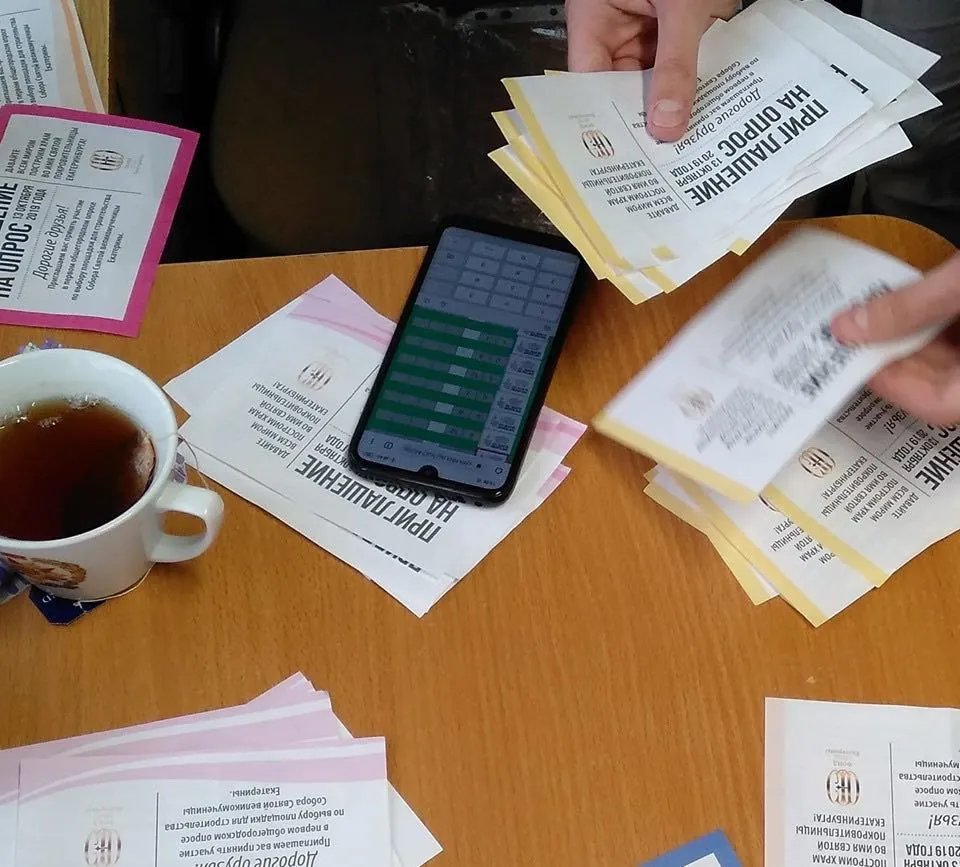 Представитель Фонда пересчитывает приглашения на голосование, которые раздавали бюджетникам. У разных организаций они различались по цветам, отмечали наблюдатели. Фото: Владислав Постников.