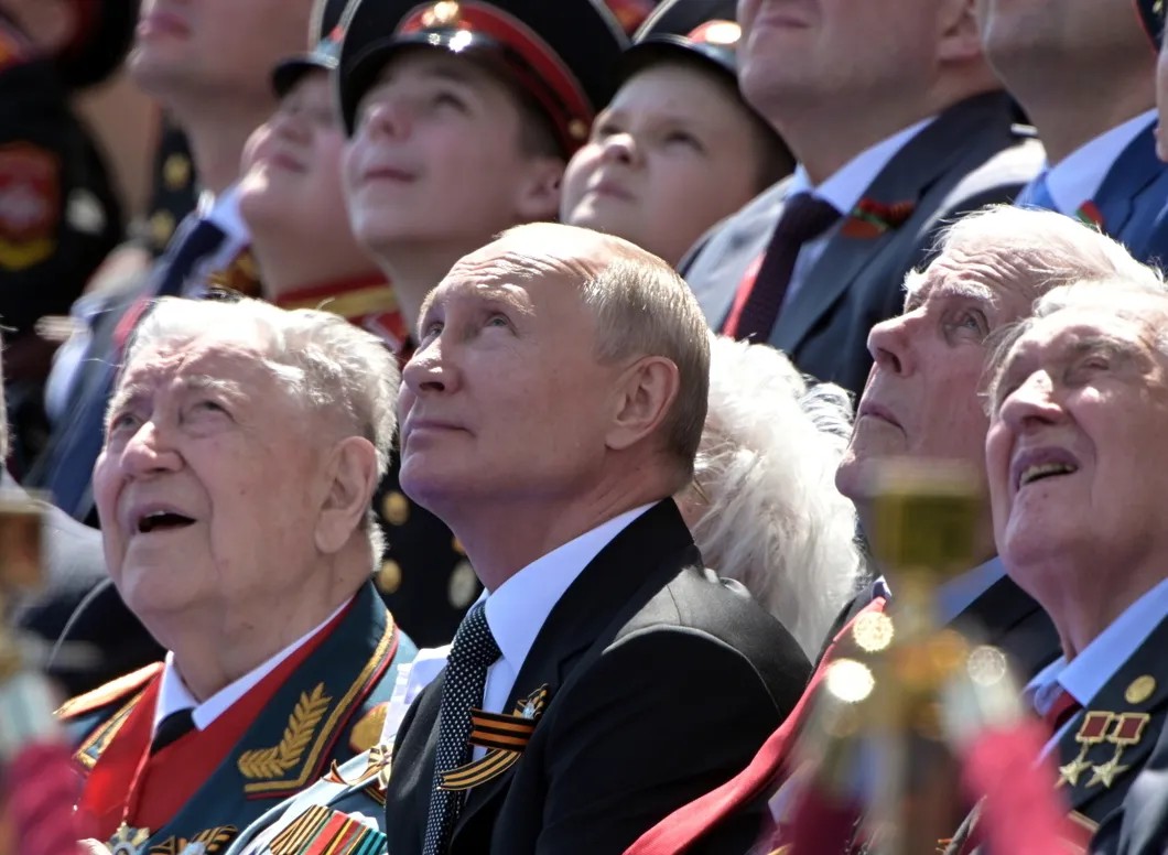 Владимир Путин вместе с ветеранами наблюдает за воздушной частью парада. Фото: Reuters