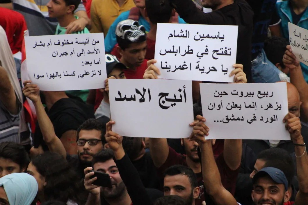 Сирийские беженцы с антиасадовскими лозунгами. Фото: Ахмад Аль Кусейр