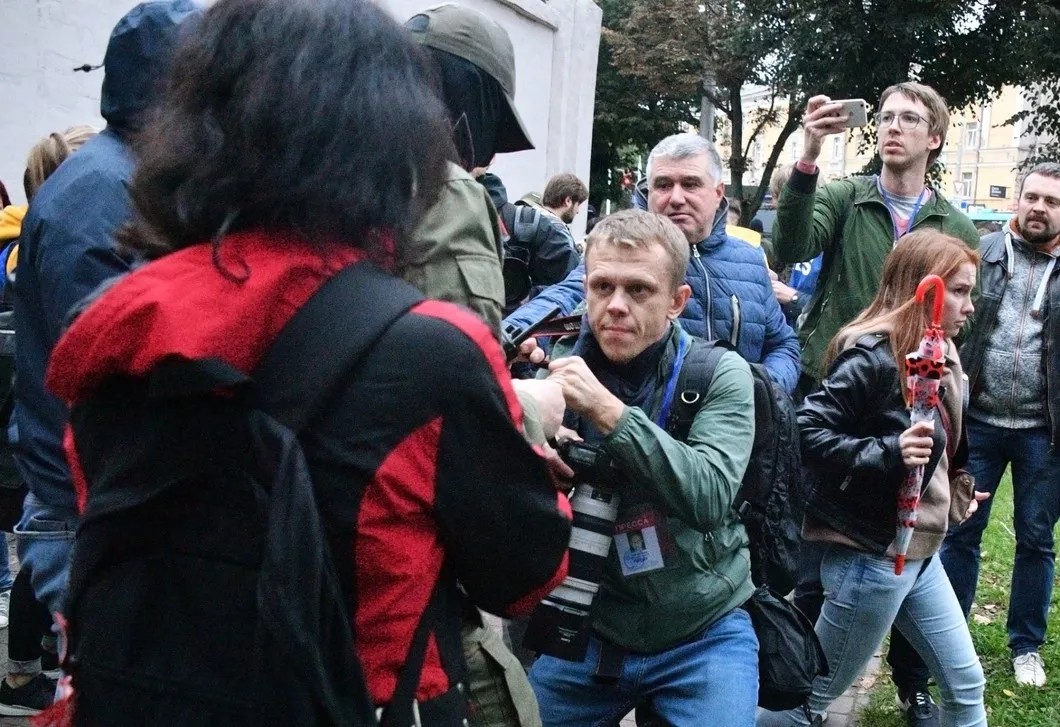 Человек в форме отбирает камеру у журналиста во время протестов в Минске. Фото: РИА Новости