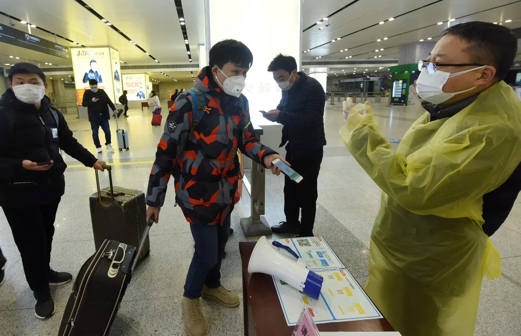 Прибывшие на вокзал Гуанчжоу показывать зеленые QR-коды как свидетельство того, что им можно передвигаться. Фото: Reuters