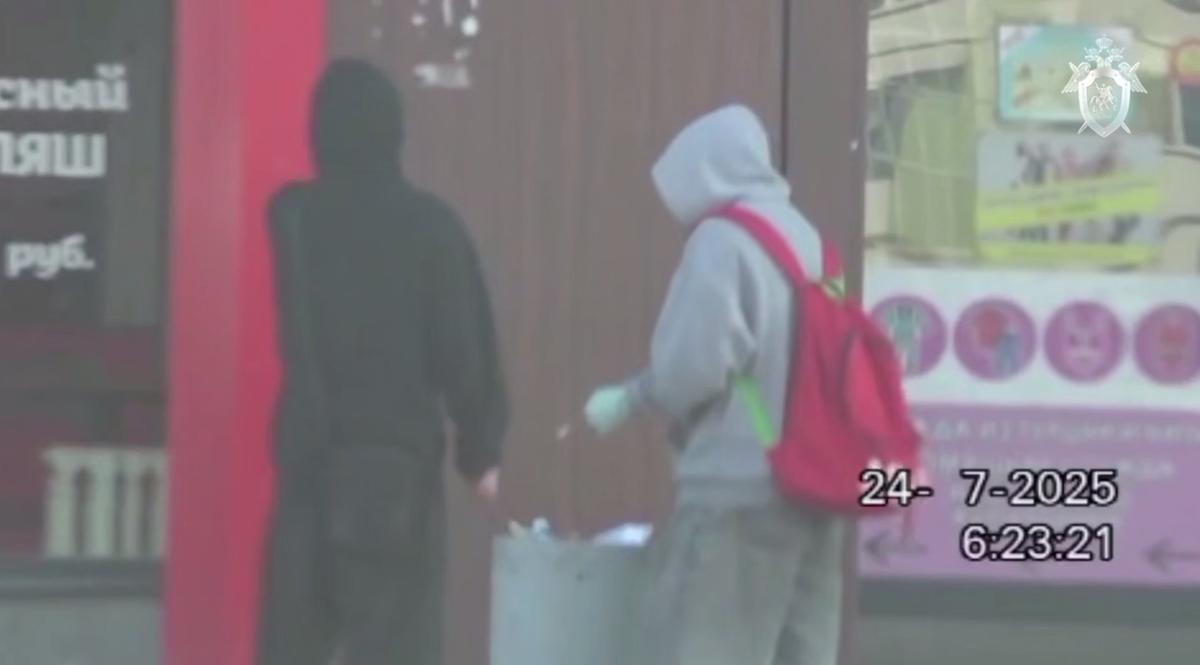 Подозреваемые выбрасывают грязные медицинские перчатки и палку с ватой в урну у магазина. Кадр из видео, приобщенного к материалам дела