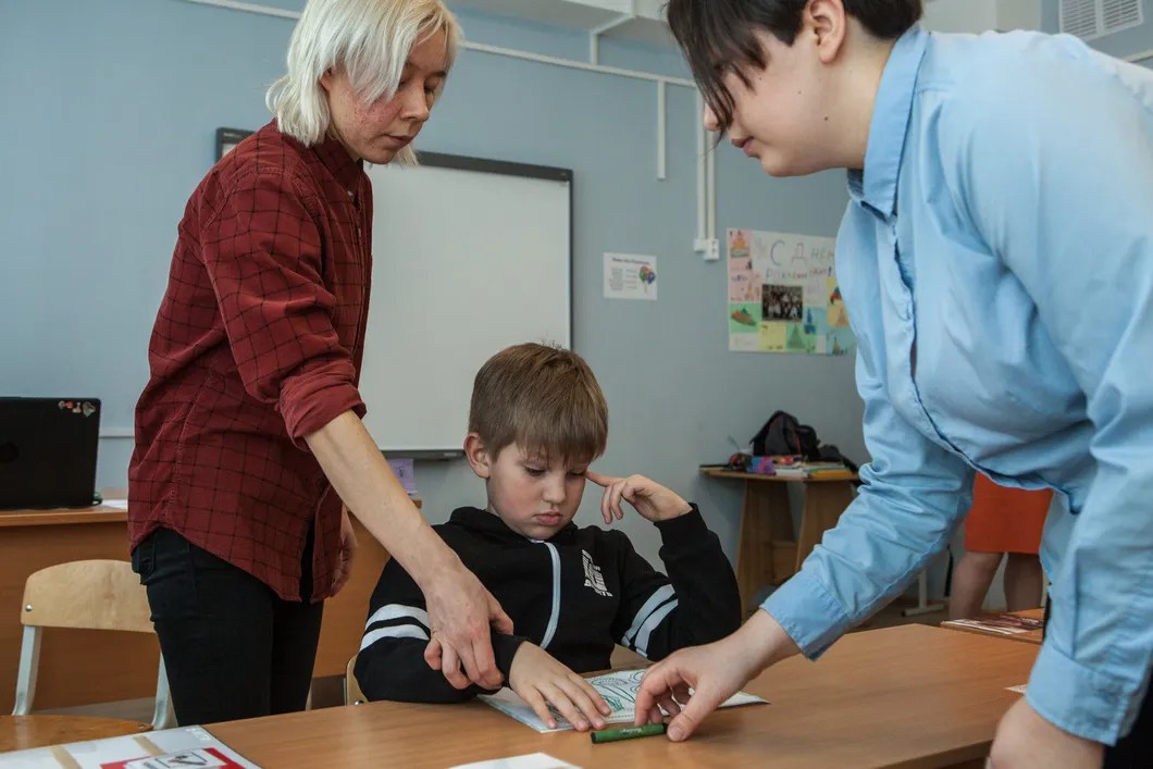 Семен занимается в классе. Рядом тьютор и учитель. Фото: Елена Лукьянова / «Новая в Петербурге»