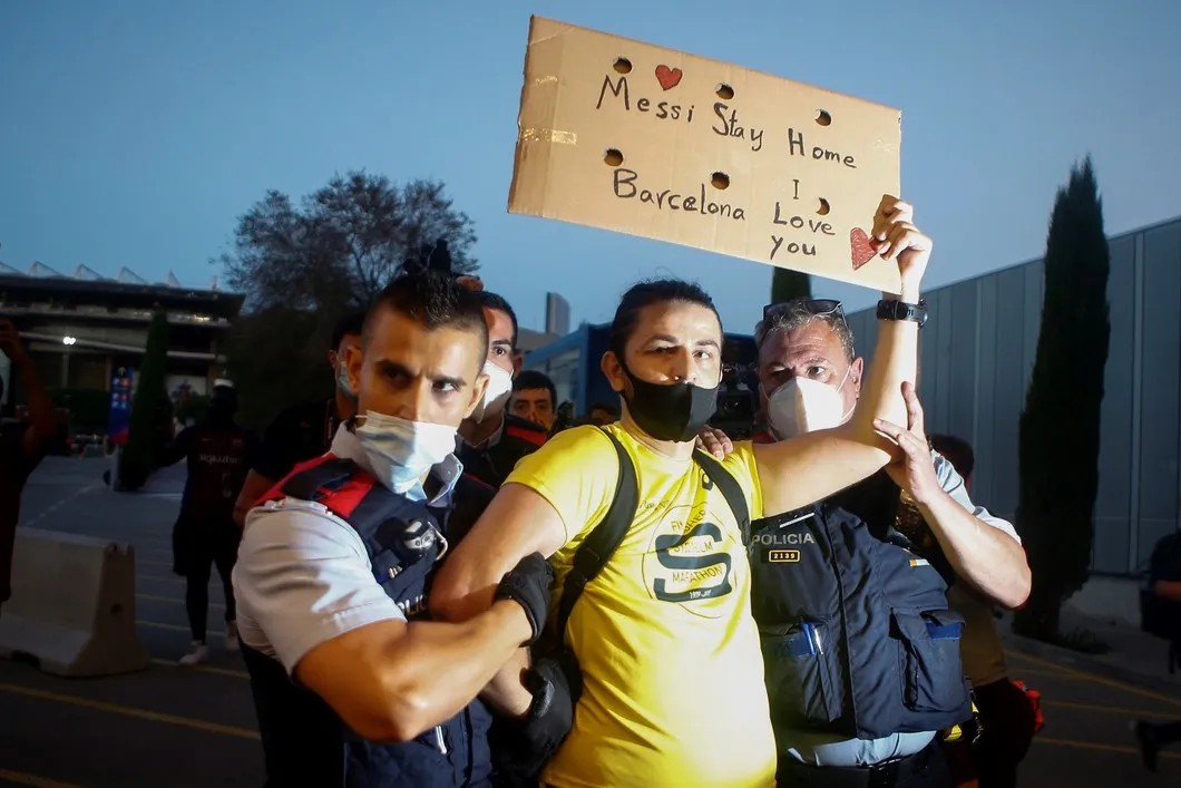 Полиция задерживает пытавшегося проникнуть на стадион поклонника «Барселоны» с плакатом в поддержку Лионеля Месси. Барселона, 25 августа. Фото: ЕРА