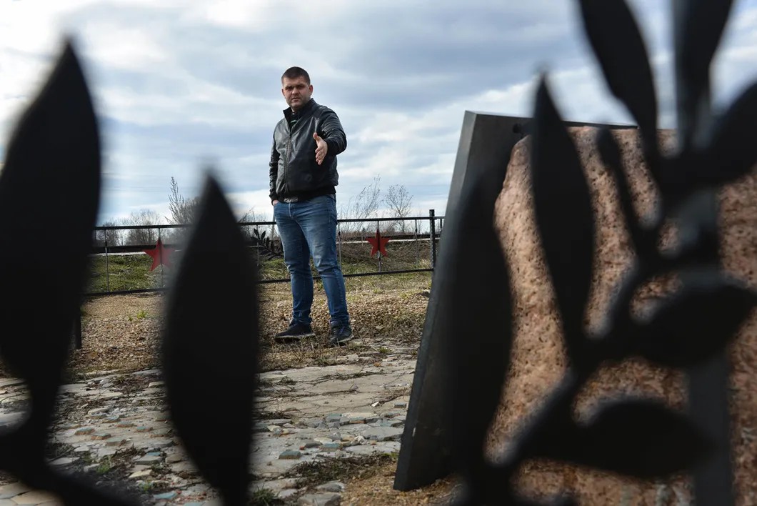 Андрей Калашников около поставленного им памятника на месте разрушенной станции Осуга. Фото: Виктория Одиссонова / «Новая»