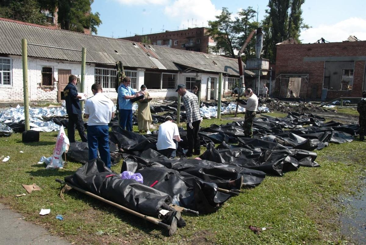 Следователи осматривают тела погибших заложников во дворе школы. Фото: Дмитрий Беляков