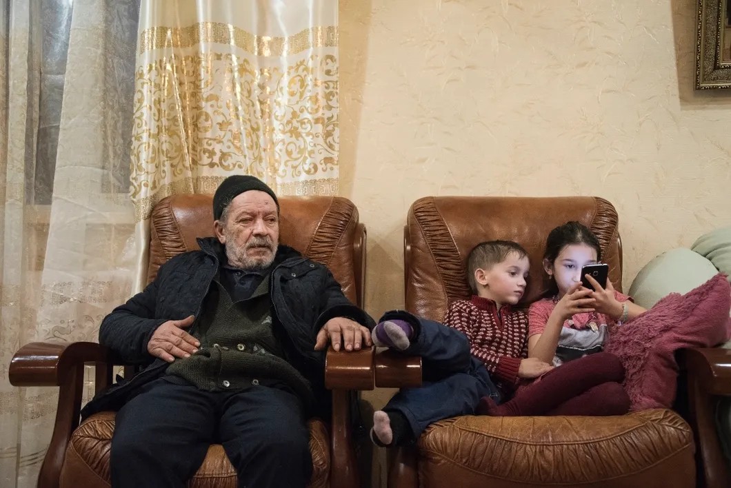 Михаил Иванович с правнуками. Фото: Виктория Одиссонова / «Новая газета»