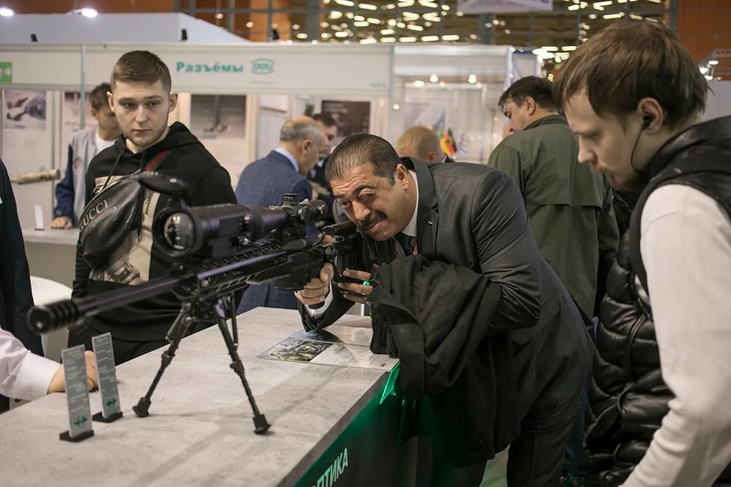 Палестинский гость выставки тестирует прицел винтовки у стенда со специальной оптикой. По славам организаторов, в выставке приняли участие представители 14 стран. Фото: Влад Докшин / «Новая газета»