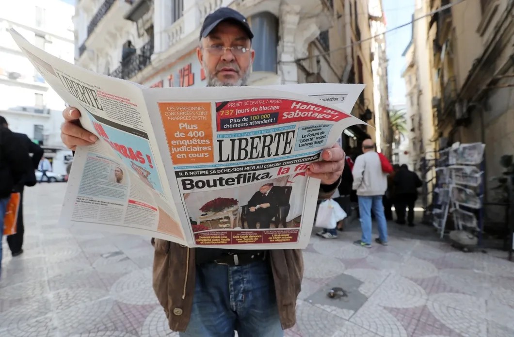 Житель Парижа читает алжирскую газету с передовицей: «Бутефлика, конец!». Фото: EPA
