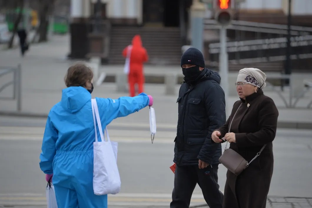 Волонтер раздает многоразовые маски на улице в Екатеринбурге. На Урале и в Забайкалье ввели масочный режим с 1 по 11 мая. Фото: РИА Новости