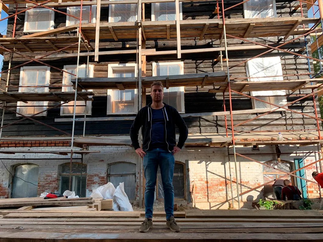 Предприниматель Алексей Будников на фоне деревянного дома, который он реставрирует уже третий год. Фото Илья Азар / «Новая»