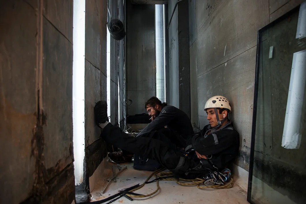 Двое членов бригады ждут товарищей на техническом этаже. Фото: Виталий Кавтарадзе / специально для «Новой»
