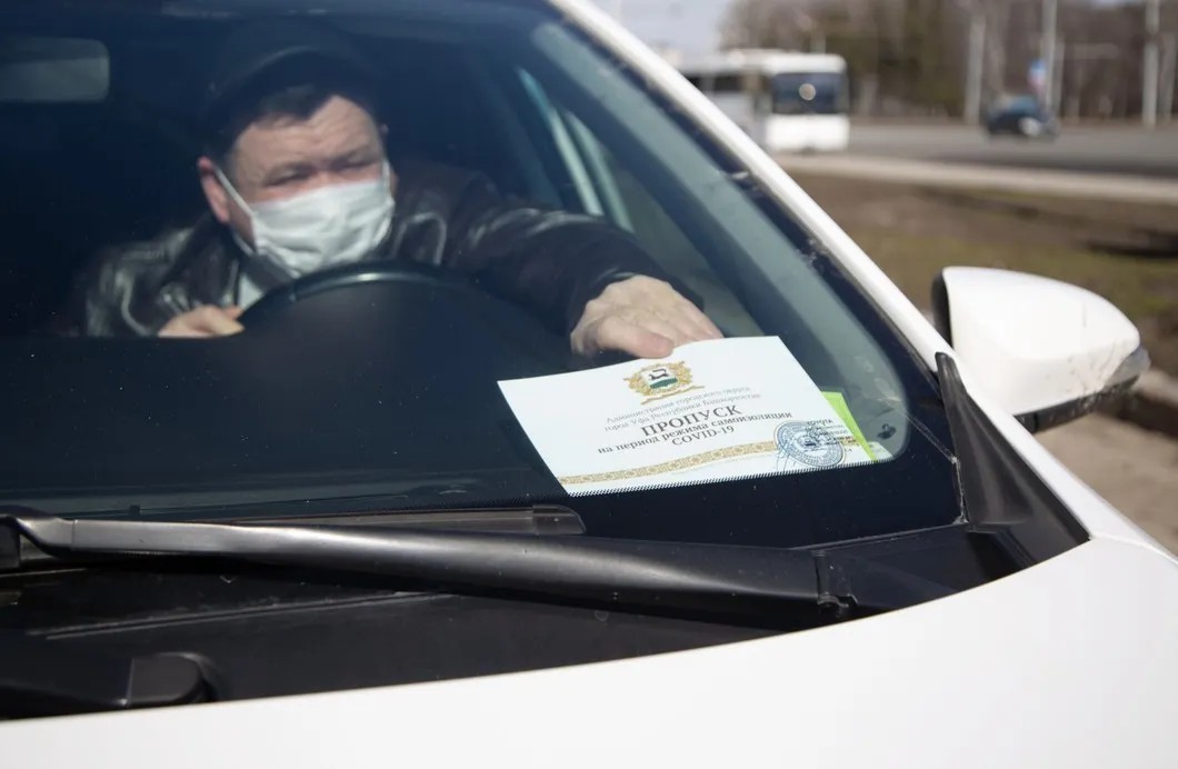 Водитель кладет под стекло специальный пропуск для перемещения граждан в Уфе. Фото: РИА Новости