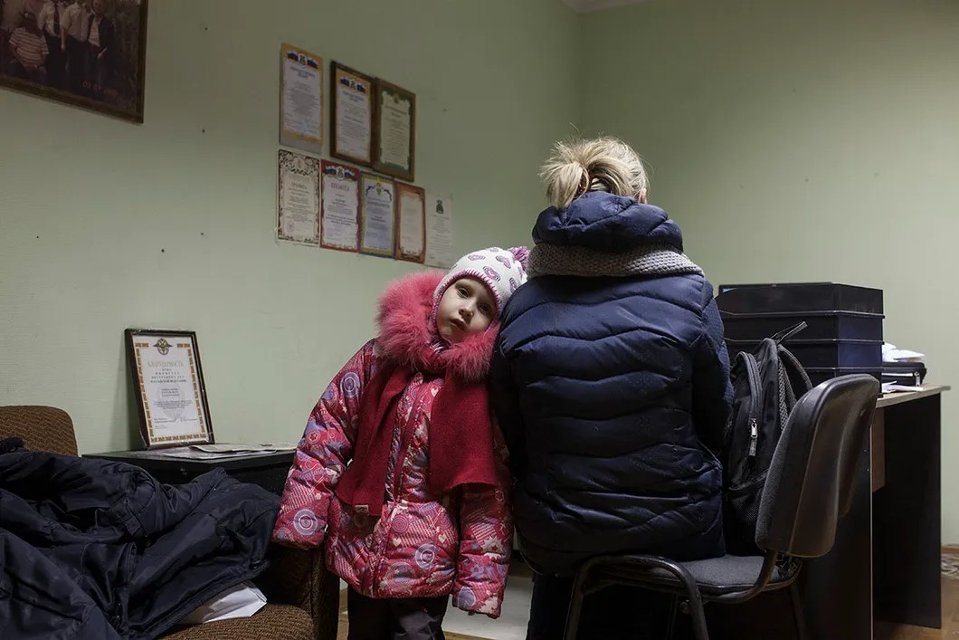 Аня в полиции с мамой. Участковый записывает их заявление. Фото: Влад Докшин / «Новая газета»