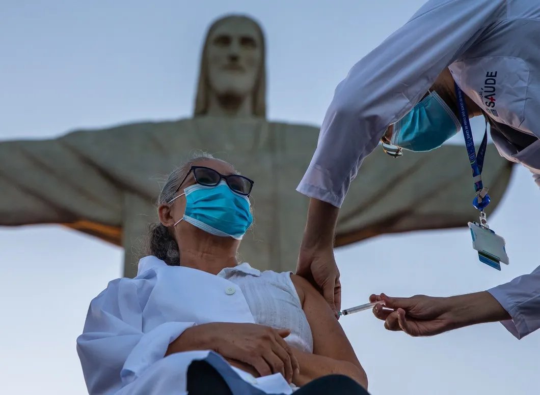 Медсестра из муниципальной больницы Рио-де-Жанейро проходит вакцинацию возле статуи Христа-Искупителя. Фото: Getty Images