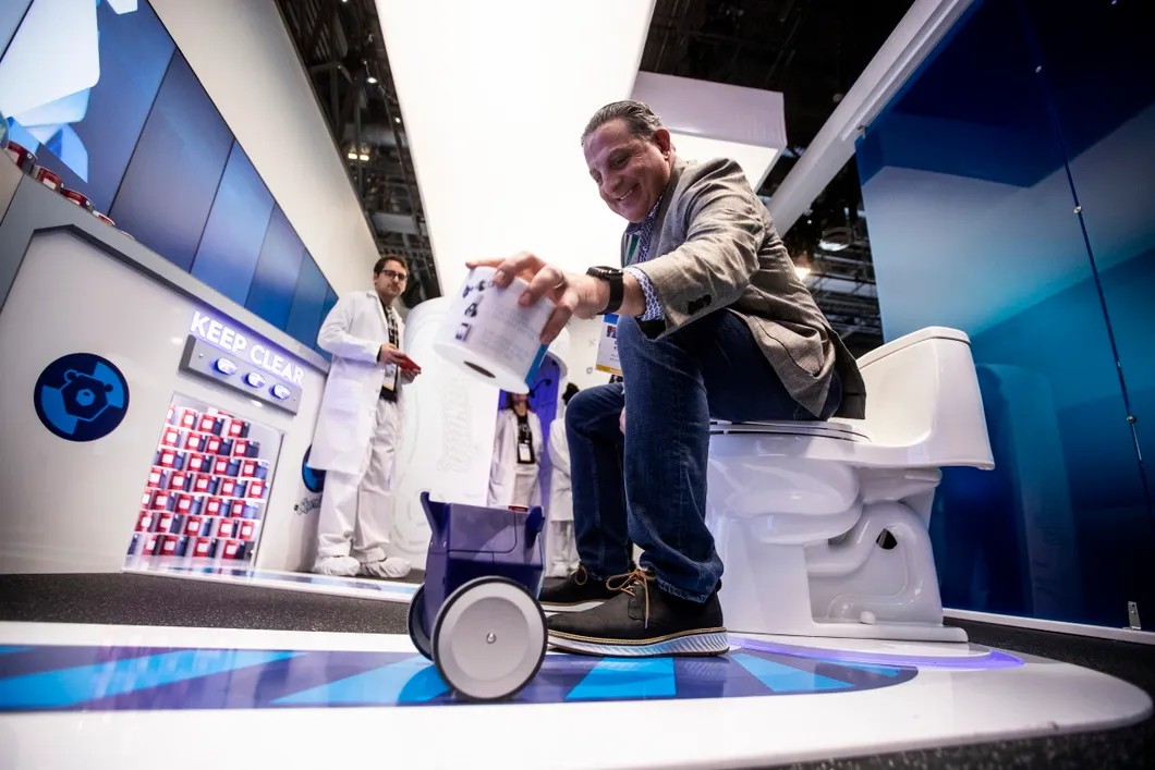 Мужчина тестирует робота для доставки туалетной бумаги на выставке Consumer Electronics Show. Фото: EPA