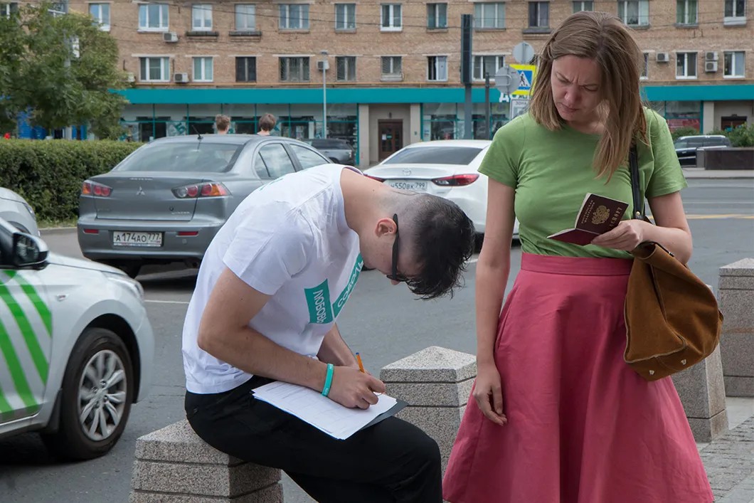 Жительница 43 округа ставит подпись в поддержу Любови Соболь. Фото: Светлана Виданова / «Новая»