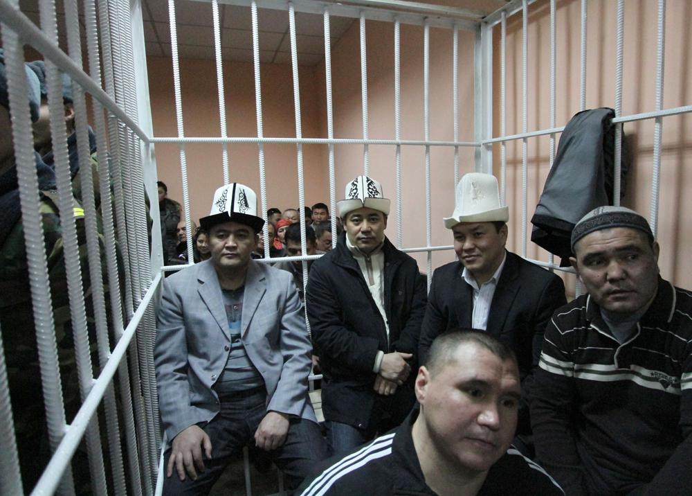 Депутаты Камчыбек Ташиев, Садыр Жапаров, Талант Мамытов (на втором плане слева направо) и их телохранители, обвиняемые в организации попытки госпереворота, во время заседания суда в Бишкеке. Фото: РИА Новости