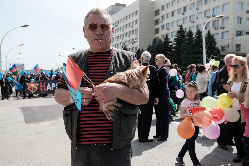 Участник первомайского шествия с щенком в центре Луганска. Фото: Антон Карлинер