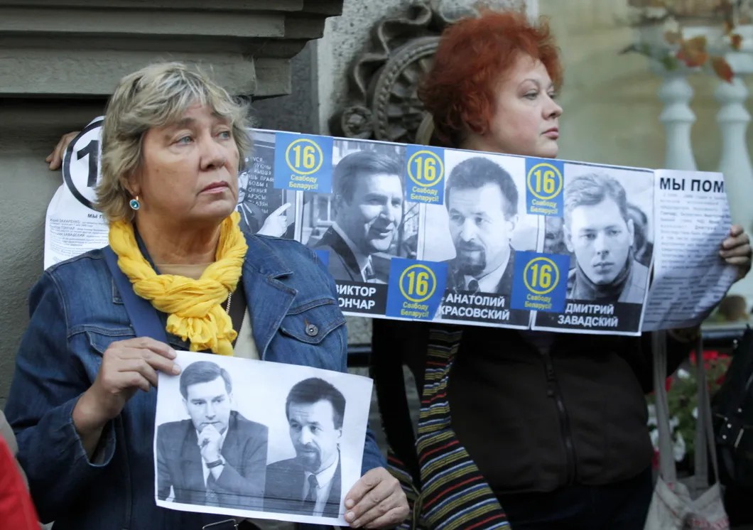 Протестующие держат портреты Гончара и Красовского на оппозиционном митинге в Минске. Фото: EPA