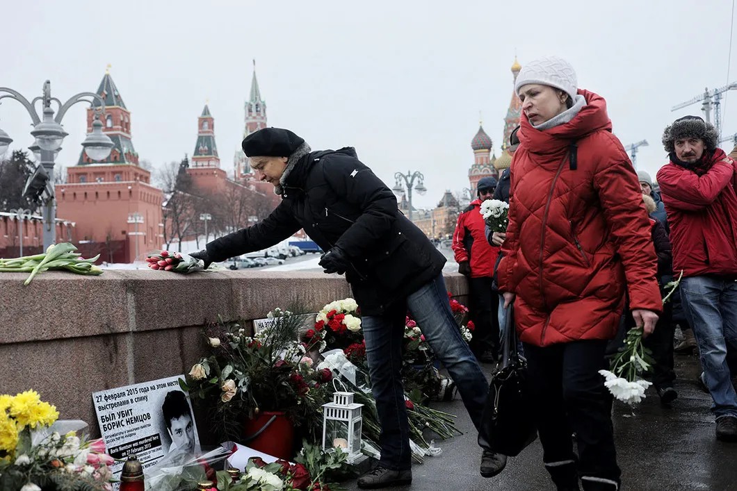 Участники марша кладут цветы к мемориалу Немцов мост. Проход к нему был затруднен из-за реконструкции. Сотрудники полиции не давали большому количеству людей там скопиться. Фото: Влад Докшин / «Новая газета»