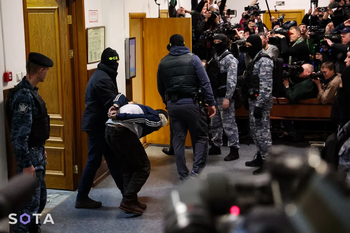 В зал суда заводят Саидакрами Муродали Рачабализоду. Именно ему силовики отрезали ухо во время допроса. Фото: SOTA