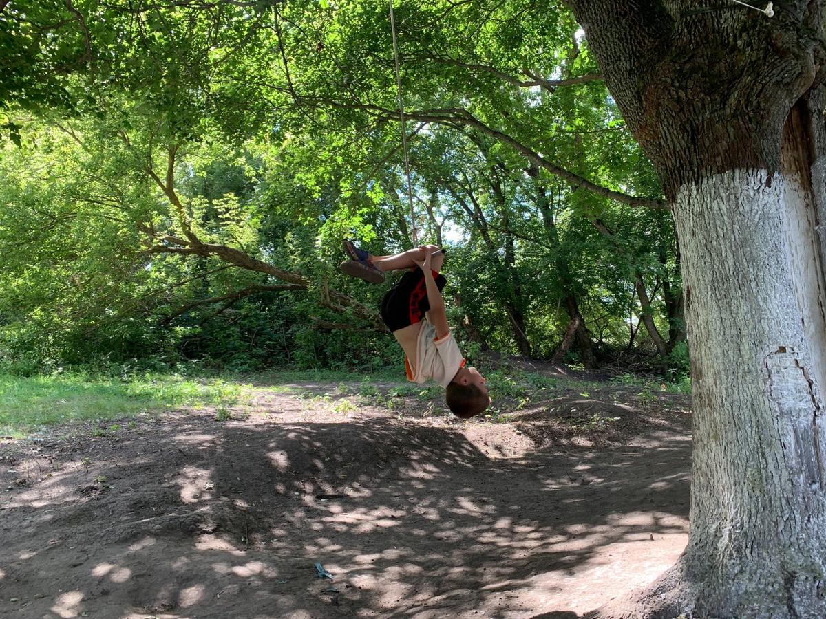 Мальчики качаются на качелях у временного дома семьи Лены и Володи. Фото: Татьяна Васильчук / «Новая газета»