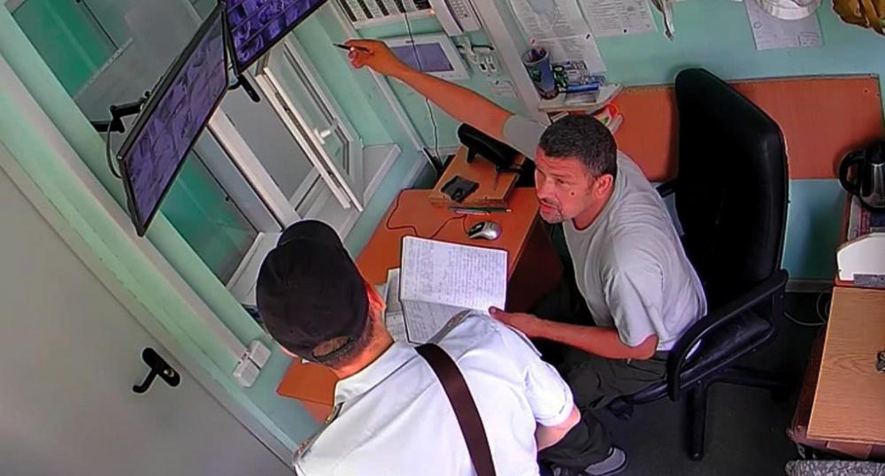 Охранник Олег Д. показывает полицейскому видеозаписи с камер в интернате