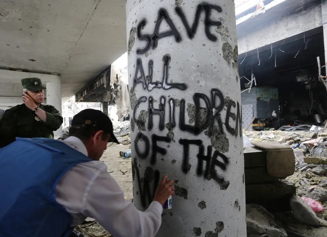 Помощник генсека ООН по правам человека оставляет надпись: «Спасите детей войны» на развалинах Донецкого аэропорта. Июнь 2016. Фото: ТАСС