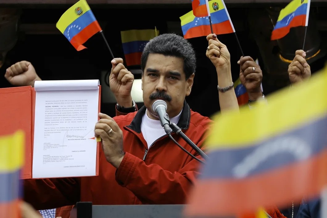 Президент Мадуро в группе сторонников демонстрирует венесуэльцам подписанный декрет о созыве Ассамблеи по принятию новой конституции страны. Фото: Reuters