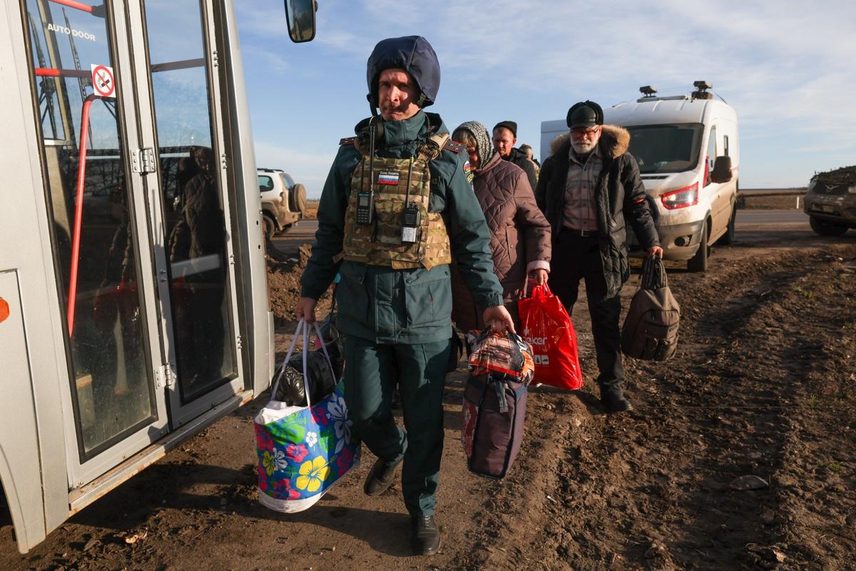 Граждане из освобожденного города Суджа и сотрудник МЧС РФ во время эвакуации. Фото: Максим Григорьев / ТАСС